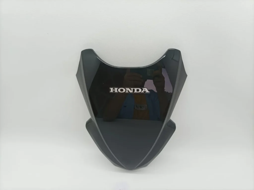 visor honda vario 160 belum terpasang diletakkan di atas display berwarna abu-abu polos